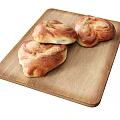 Three Freshly Baked Heart Shaped Bread Rolls on Wooden Cutting Board
