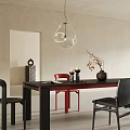 Black Dining Table With Red And Black Chairs Vase Twigs Book And Transparent Pendant Light