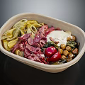 Delicious Pasta Paper Bowl with Corned Beef White Sauce Cherry Tomatoes Chickpeas and Fresh Greens