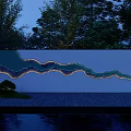 Scenic Feature Wall With Wavy Design Illuminated At Night Surrounded By Trees And Water