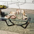 Modern Oval Glass Coffee Table with Black Metal Legs and Decorative Sculptures on Green Rug