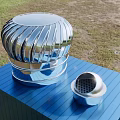 Silver Metal Round Corrugated Air Conditioner Vent on Blue Cuboid Platform with Small Perforated Vent