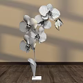 Floral Display Featuring Purple Orchids in Green Vase with White Base on Wooden Floor