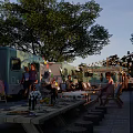 Evening RV Camping Scene With String Lights Outdoor Table Chairs And Trees