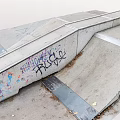 Outdoor Concrete Skate Ramp Area Featuring Colorful Graffiti Metal Strips And Dry Leaves