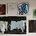 Colorful Wall Art Display With Various Paintings Including Portrait And Abstract Designs