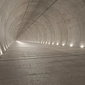 Concrete Elevator Aisle With Arched Ceiling And Side Lighting Leading To Bright End