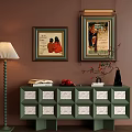 Green Console Cabinet with White Decorative Drawers Wall Art Floor Lamp Vase and Books