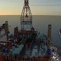 Offshore Oil Drilling Platform Industrial Equipment with Drilling Tower and Crane under Sunset Sky