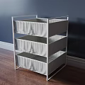 White Three Tier Storage Shelf Unit With Fabric Bins Against Navy Wall And Wood Floor