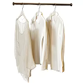 Three White Clothes Hanging On Metal Hanger For Stylish Wardrobe
