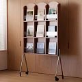 Wooden Tiered Bookcase With Wheels Holding Books Frames By Wooden Wall Window With Blinds