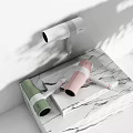 Modern Electric Hairdryers In White Pink Green On Marble Countertop With Plant Shadows