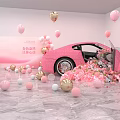 Pink Sports Car Surrounded By Colorful Balloons And Flower Petals In Room