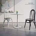 Modern White Round Dining Table Set with Black White Chairs Green Plant and Wall Art