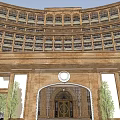Classical Hotel Building With Curved Exterior Arched Entrance Golden Doors And Green Trees