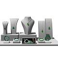 Green Jewelry Display Featuring Necklaces Pendants Bracelets On White Mannequin Stands