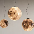 Three Textured Moon Surface Pendant Lights With Warm Glow Hanging On Gray Wall