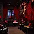Eerie Interior Scene With Red Curtains Stone Walls Skeleton Red Lanterns And Cushions