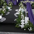 Floral Installation for Wedding Ceremony with Purple Drapery White Candles and Greenery Pathway