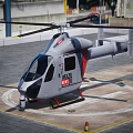 Gray Helicopter With Red Accents Parked On Helipad With Circular Markings