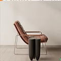 Modern Brown Leather Leisure Chair With Metal Frame And Side Table Against Light Wall