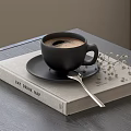 Black Coffee Cup on Eat Drink Map Book with Spoon and Decorative White Flowers