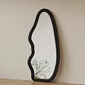 Unique Curved Black Frame Mirror on Light Beige Wall with Green Plant Reflection