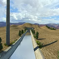 Scenic Concrete Water Canal in Arid Land With Trees Distant Mountains and Blue Sky