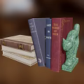 Colorful Stacked Books With Green Cat Shaped Bookend And Various Covers