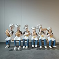 Modern Chef Sculpture Carving With Multiple Figures Holding Bread Sitting On Bench