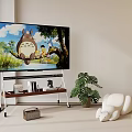 TV Displaying Totoro And Child On TV Stand Beside Green Plant And White Plush Toy