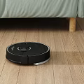Automatic Robot Vacuum Cleaner Cleaning Wooden Floor In Living Room With Sofa
