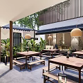 Modern Restaurant Outdoor Courtyard With Green Plants Water Feature And Wooden Tables
