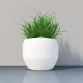 Modern Potted Plant with Green Grass in White Geometric Pot on Gray Tabletop