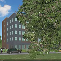Modern Multi Storey Industrial Factory Building With Lush Green Trees Surrounding Roads And Parked Vehicles