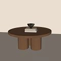 Round Wooden Coffee Table With Two Cylindrical Legs Topped With White Book And Black Bowl