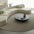 Curved Beige Sofa Set with Round Coffee Table Vase and Floor Lamp on Round Rug