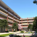 Red Brick Multi Story School Building Featuring Outdoor Courtyard Lush Green Trees And Students