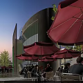Vibrant Commercial Street With High Rise Buildings Outdoor Dining Areas And Evening Lights