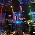Contemporary Bar Interior Design With Colorful Lighting High Stools Bar Counter And Geometric Ceiling