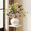 White Ceramic Vase With Pink And Yellow Flowers And Green Leaves On White Shelf