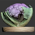 Fresh Purple Cauliflower with Green Leaves Displayed on Wooden Round Board