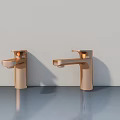 Two Copper Bathroom Faucets On Gray Countertop With Light Wall Background