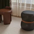 Curved Wooden And Black Leather Rope Wrapped Stools In Indoor Carpeted Space With Curtains