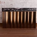 Golden Ribbed Console Cabinet With Black Marble Top Against White Brick Wall On Wooden Floor