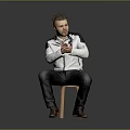 Man Sitting On Chair Clasping Hands In White Jacket Dark Pants And Brown Shoes Against Gray Background