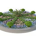 Roadside Circular Flower Bed With Central Palm Tree And Surrounding Colorful Flowers Shrubs