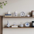 Blue and White Decorative Ceramic Vessels on Wooden Shelf with Books and Green Plant