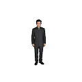 A Man Standing Full Length In Dark Colored Mao Suit Against Grey Background